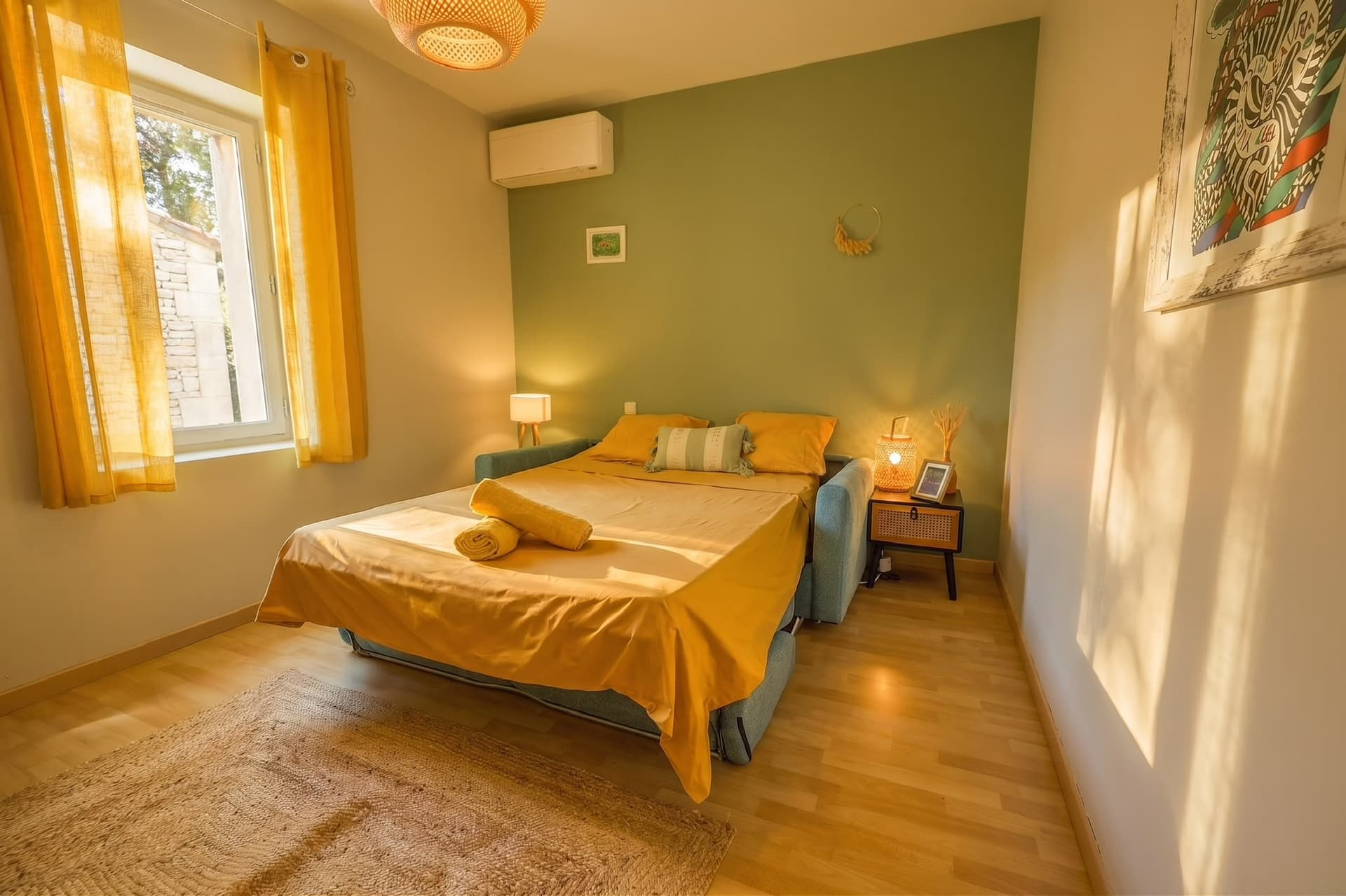 Chambre avec canapé-lit et linge de lit moutarde