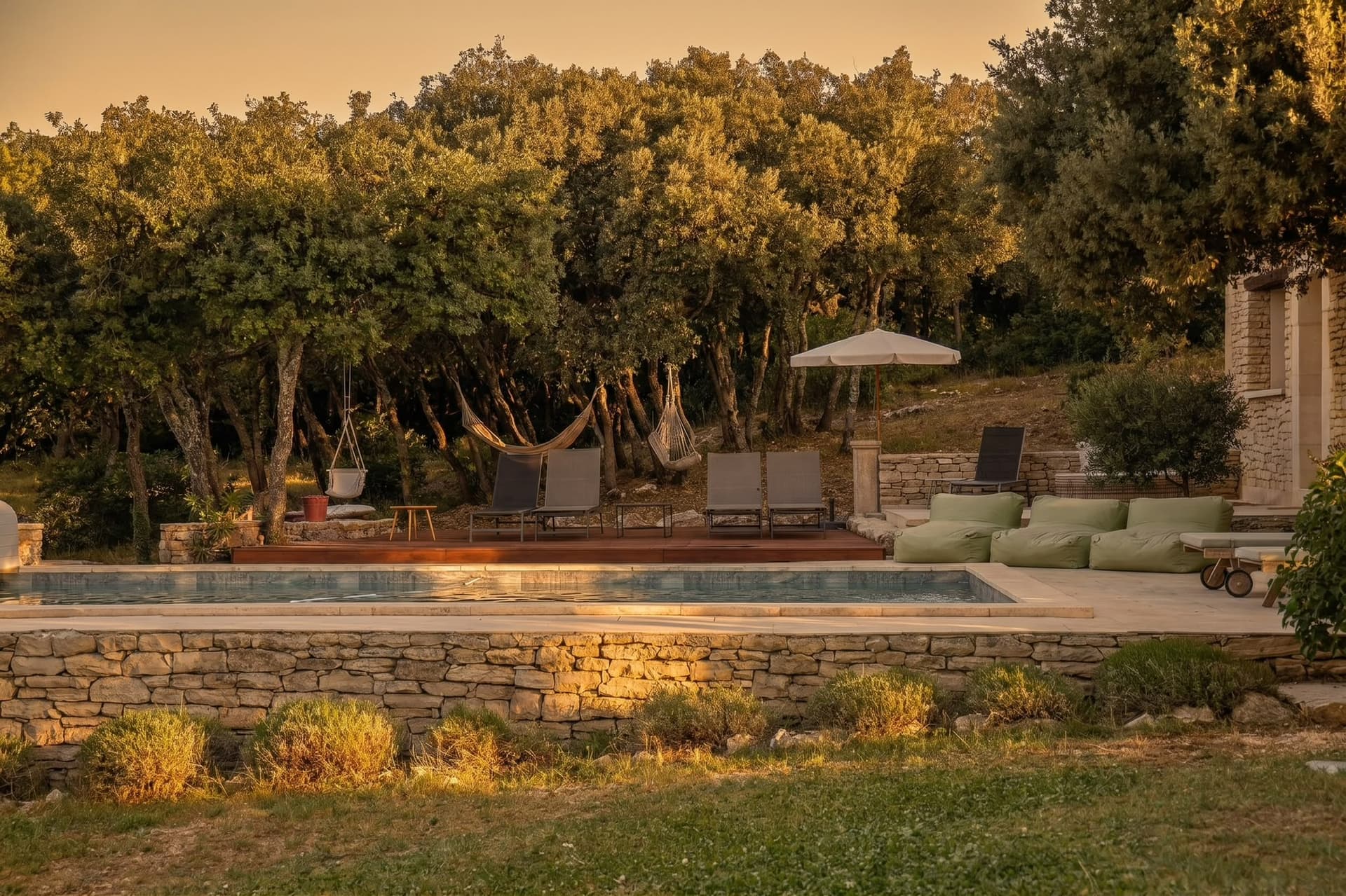 Piscine au coucher du soleil avec hamacs et bains de soleil